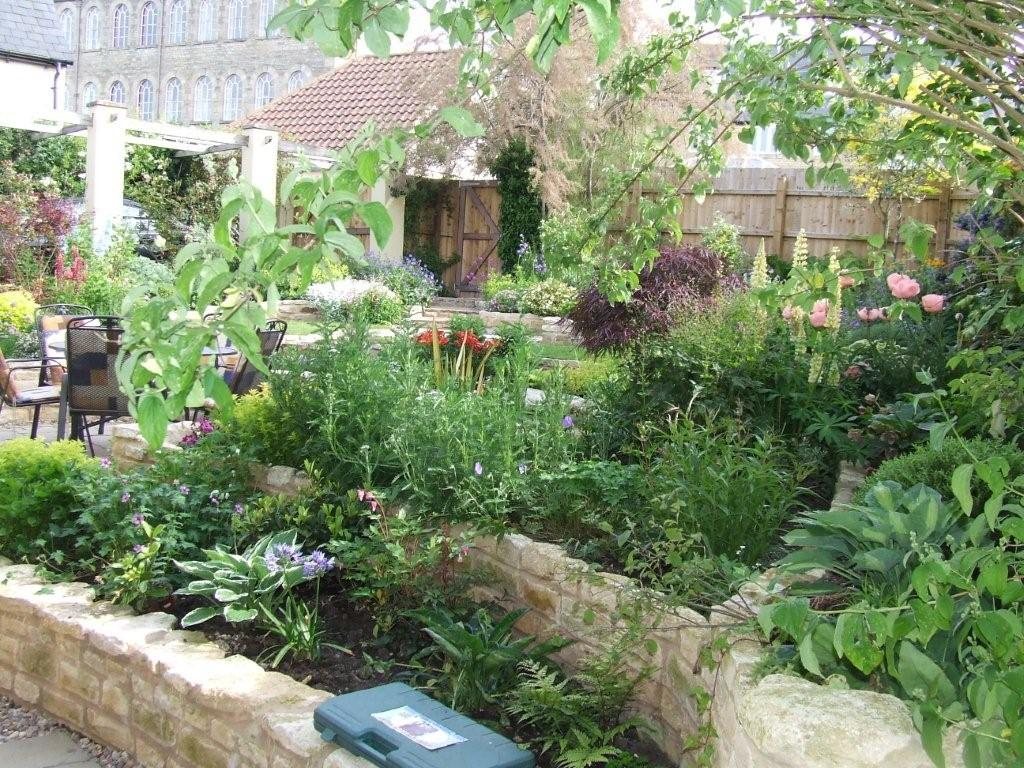 After: Curved stone raised beds going in, then planted up.