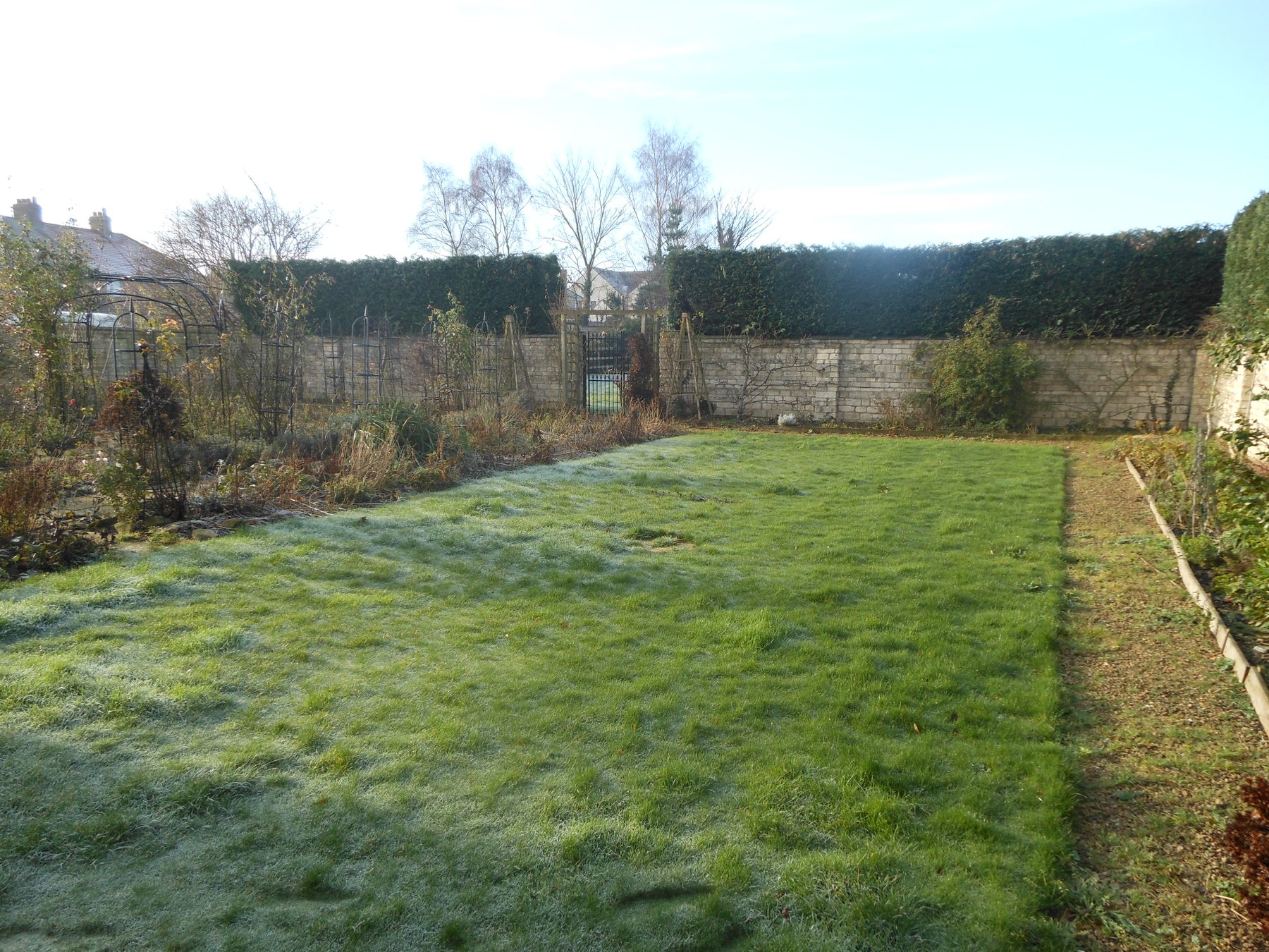 Before: A long walled lawn, laid out as beds and gravel paths.