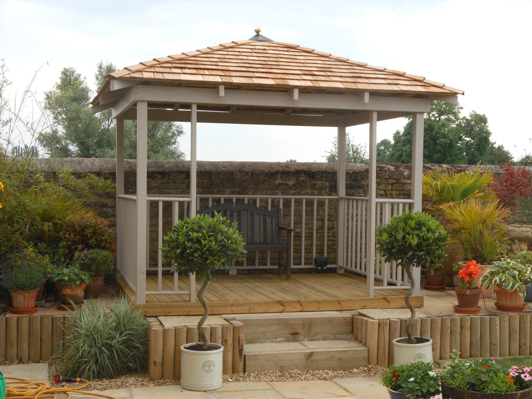 Gazebo on a sleeper base with bay trees either side