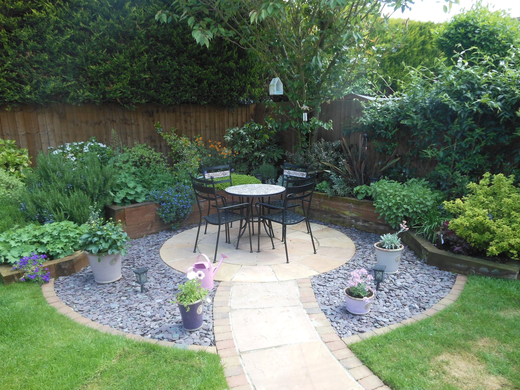 Circular patio with slate chipping borders and planting