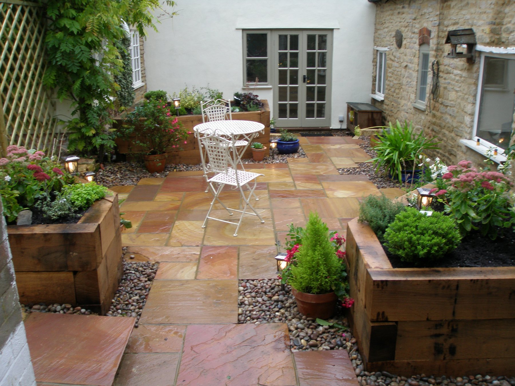 Courtyard sandstone paving with sleeper planters