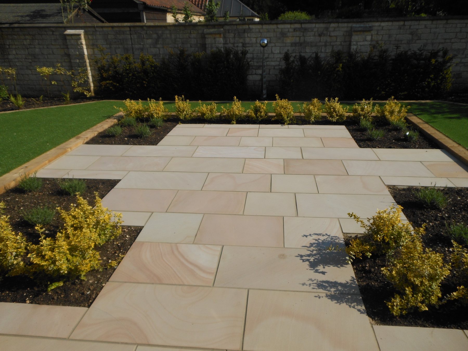 Large sandstone terrace with inset planting beds